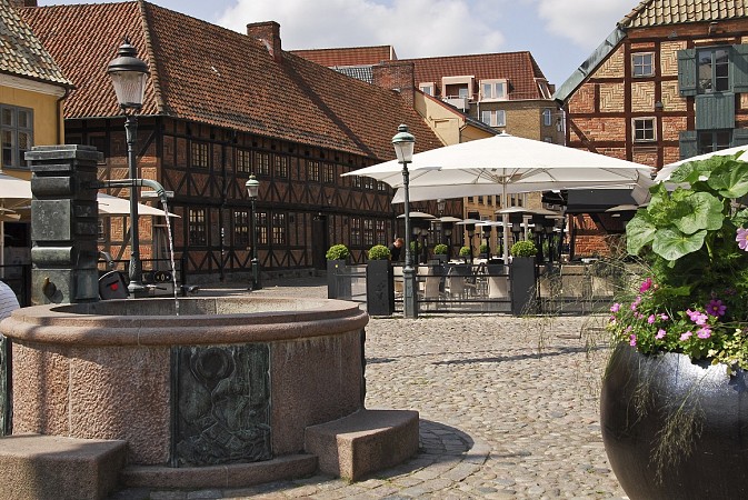 Malebné náměstí v Malmö s hrázděnými domy a venkovním posezením