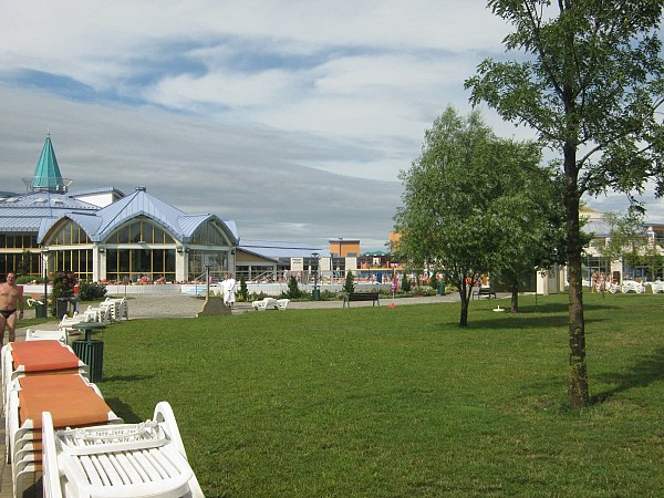 Rozsáhlý areál s travnatou plochou, stromy a lehátky